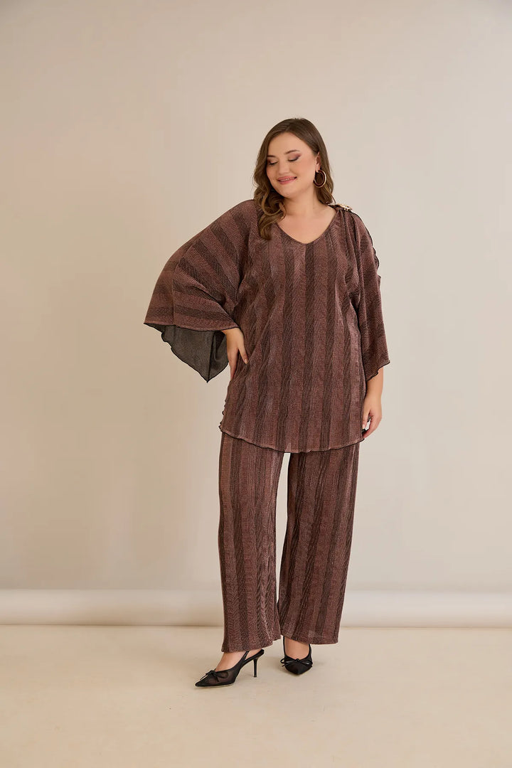 Elegantan set s prorezom na rukavu i sofisticiranim brošem