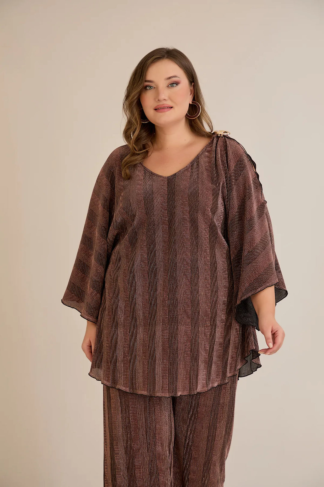 Elegantan set s prorezom na rukavu i sofisticiranim brošem