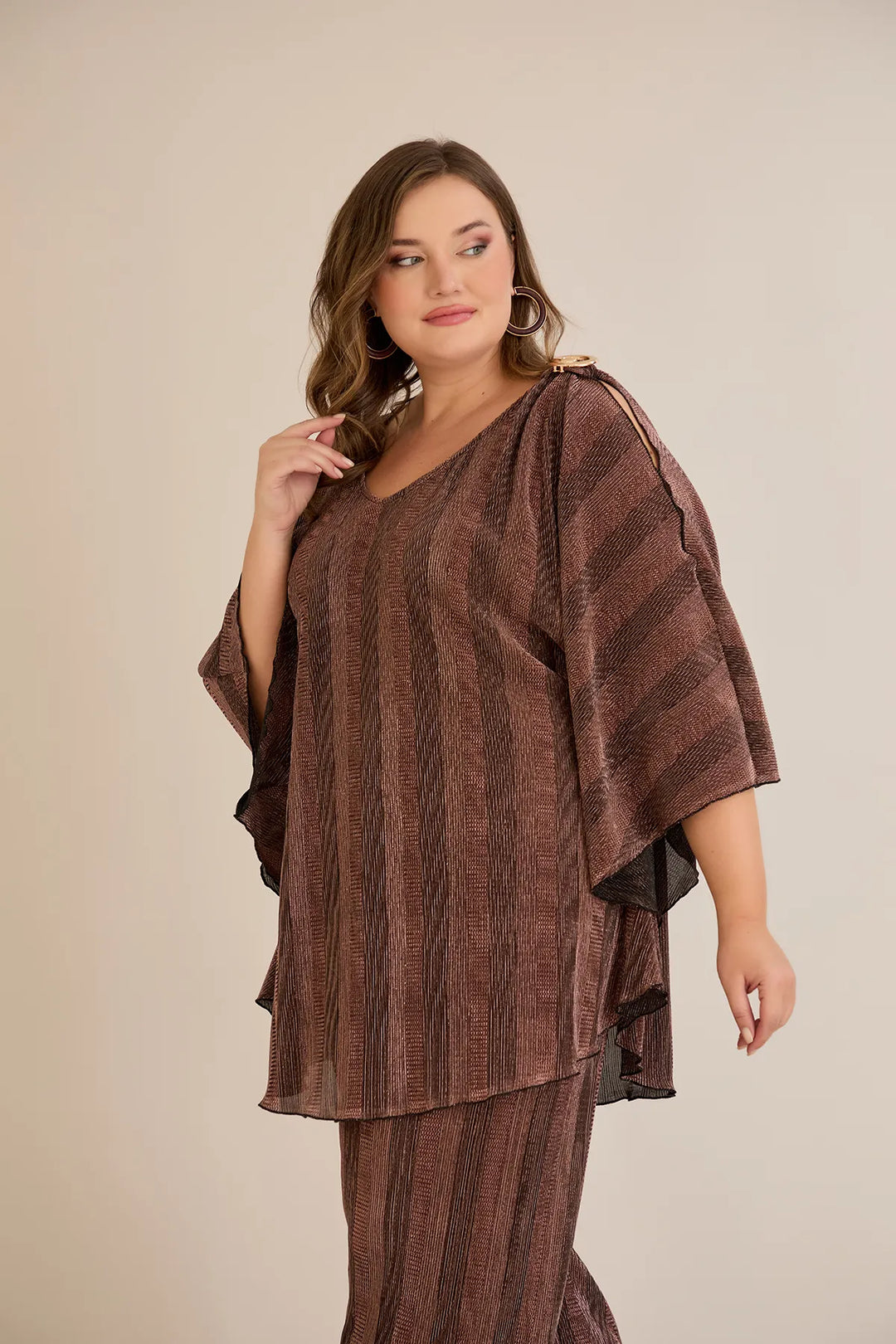 Elegantan set s prorezom na rukavu i sofisticiranim brošem