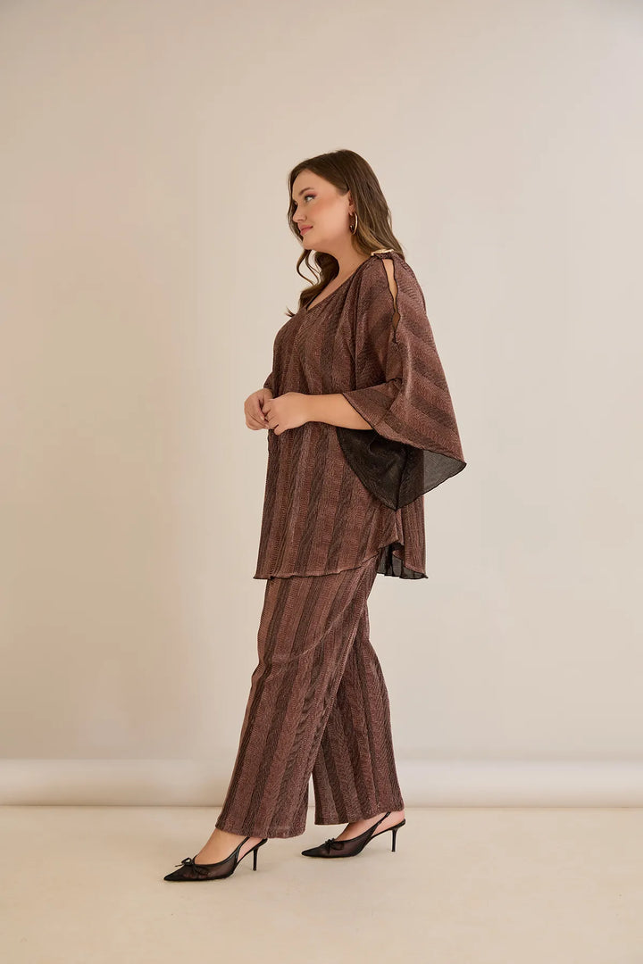 Elegantan set s prorezom na rukavu i sofisticiranim brošem