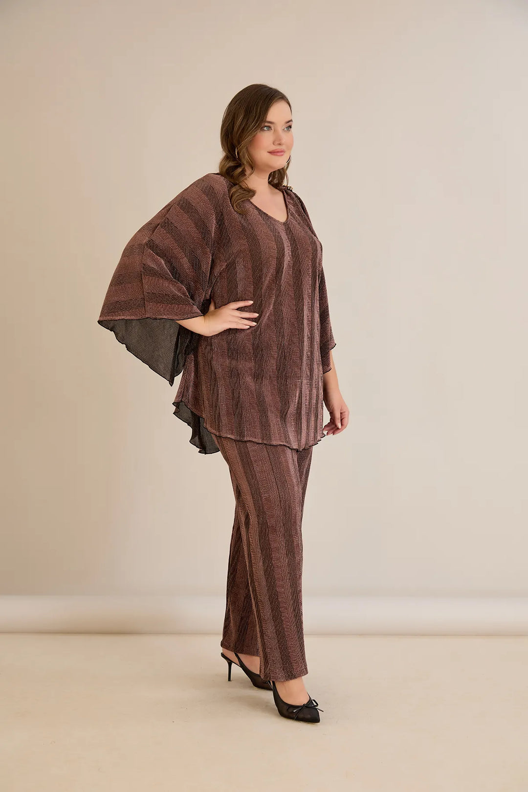 Elegantan set s prorezom na rukavu i sofisticiranim brošem