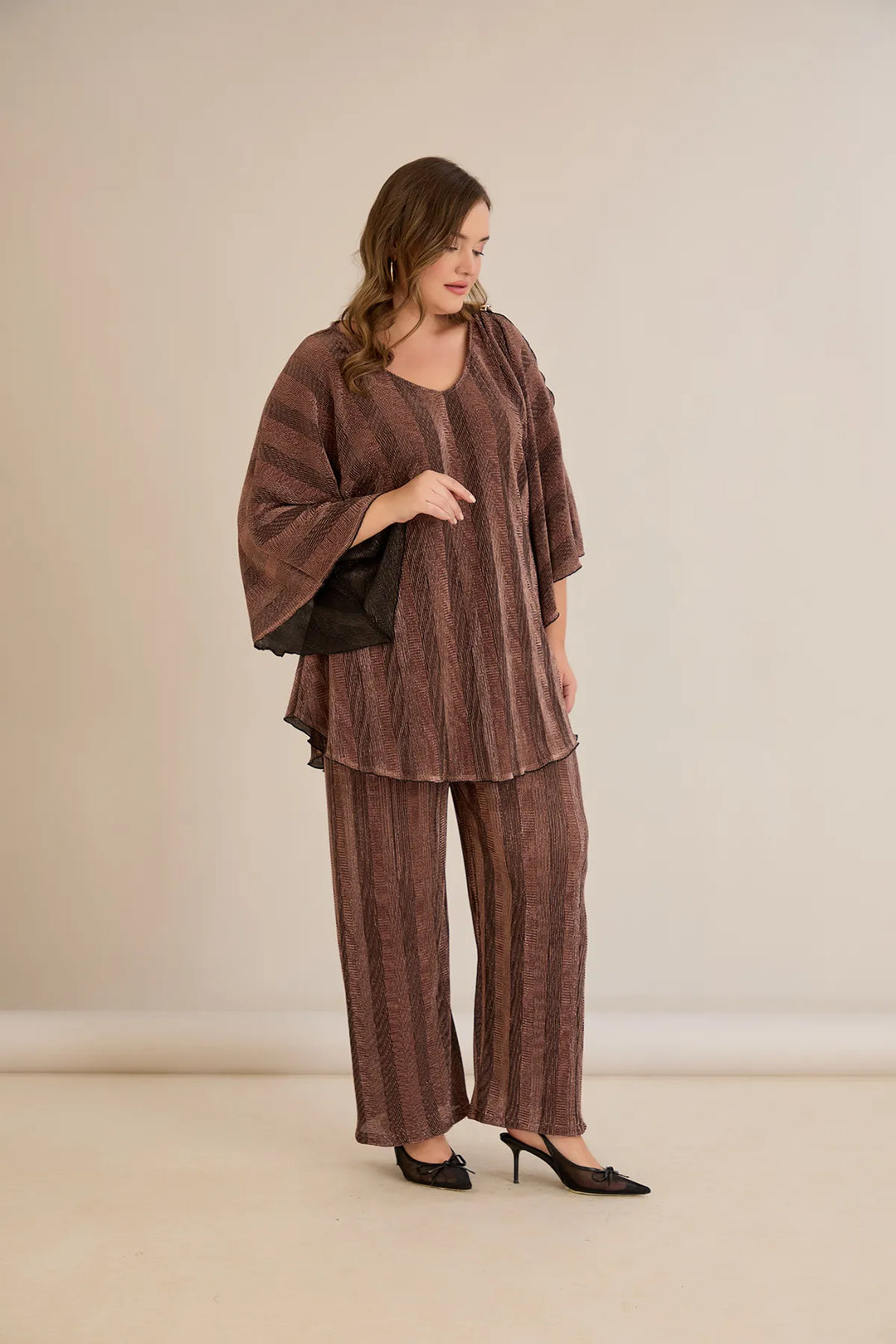 Elegantan set s prorezom na rukavu i sofisticiranim brošem