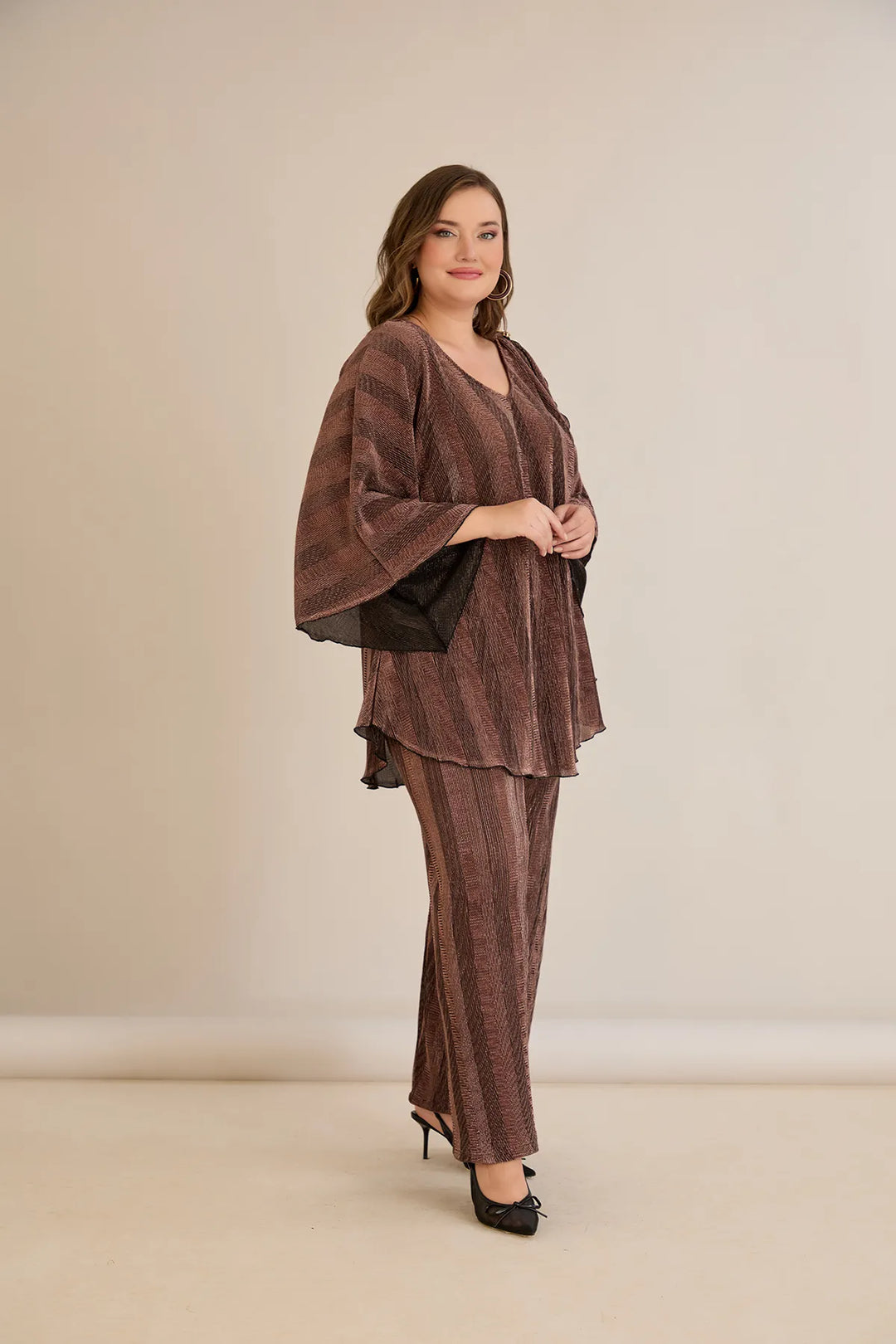 Elegantan set s prorezom na rukavu i sofisticiranim brošem