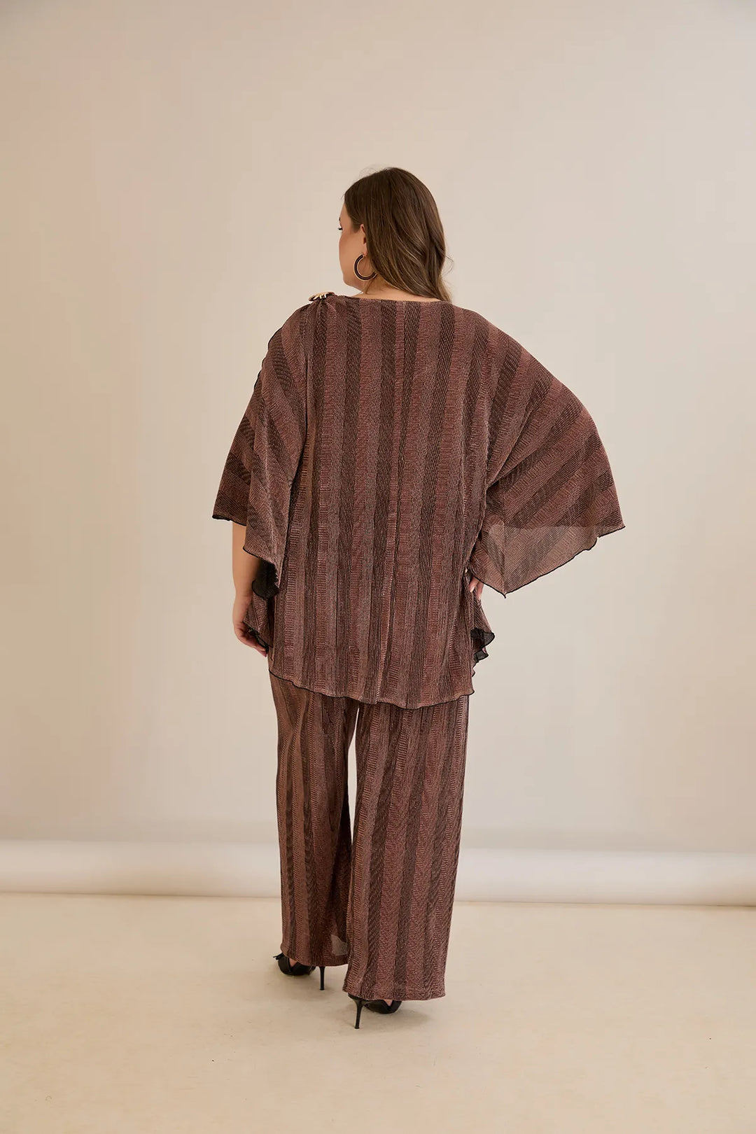 Elegantan set s prorezom na rukavu i sofisticiranim brošem